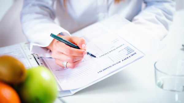 female nutritionist at desk with food and papers