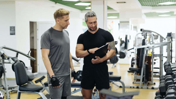 trainer and client in weight room