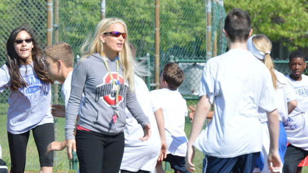 coach talking to a group of young people playing a game