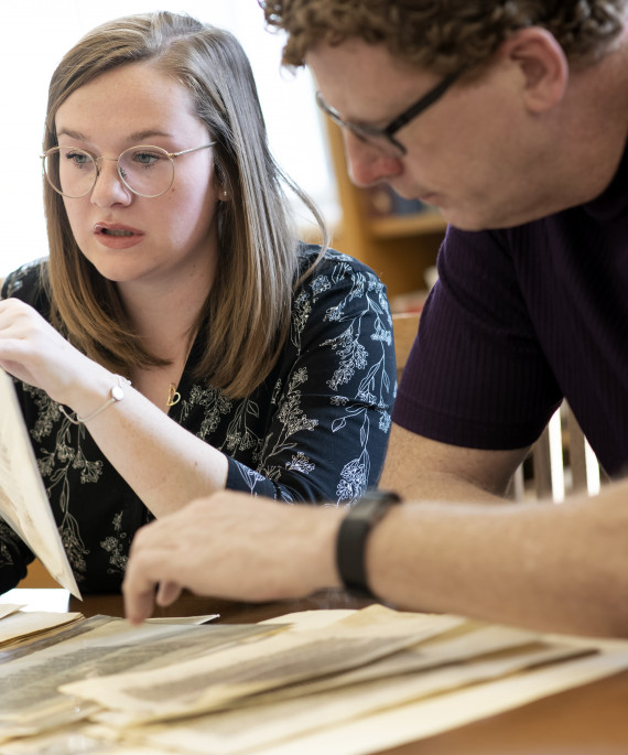 Undergraduate student Rose McCandless and her mentor Eric J. Johnson with leaves from a 13th Century Bible in the Rare Books and Manuscripts Library.