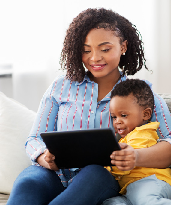 mother sitting with child looking at tablet