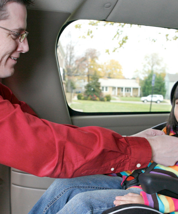 parent putting child in car seat