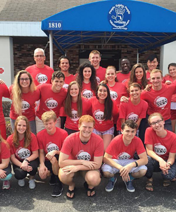 a group of people in red shirts posing for a picture