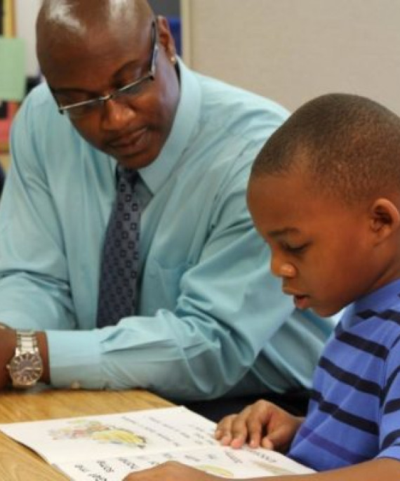 teacher helping student at desk