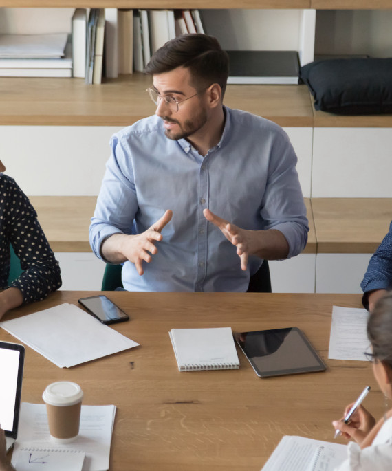 Skilled male manager talking to diverse business people at meeting