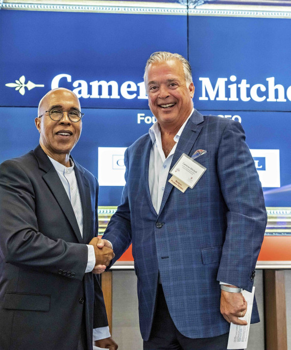 Dean Don Pope-Davis of EHE shaking hands with restaurant owner Cameron Mitchell