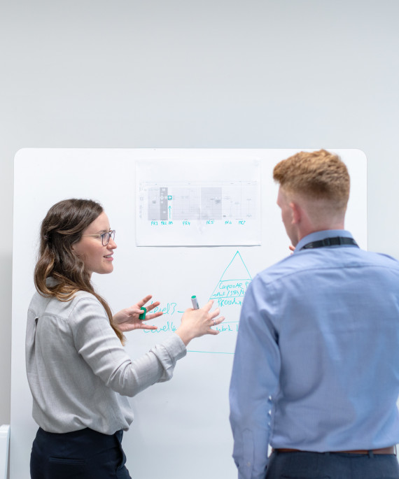 man and woman in front of graph