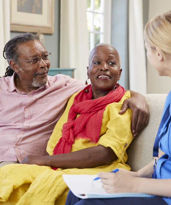 female-community-nurse-visits-senior-couple-at-home