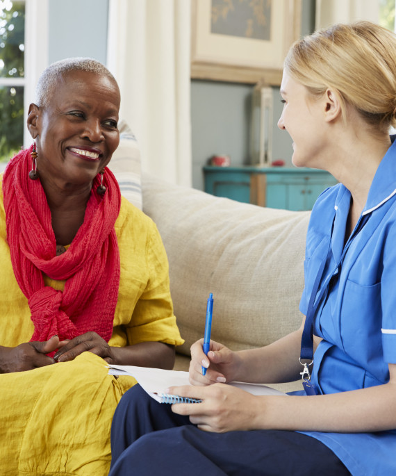 female community nurse visits senior woman at home