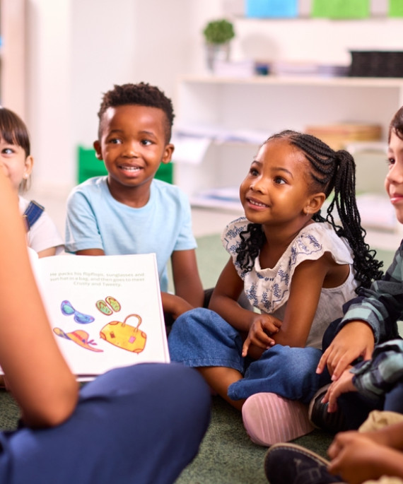 female teacher reads to elementary students