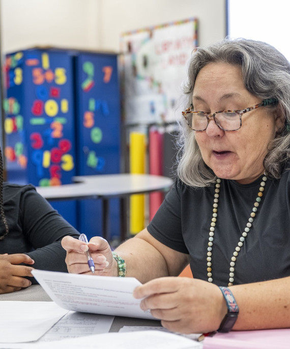 Teacher testing a with student for dyslexia in a classroom setting