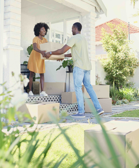 Couple moving boxes into a new house