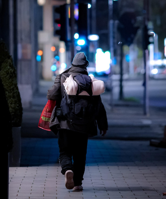 person walking in the city at night with bags