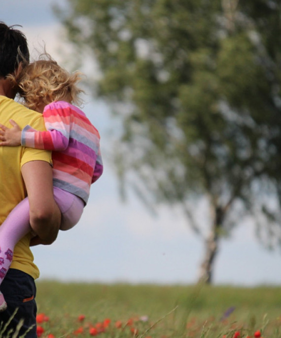 man carrying two small children