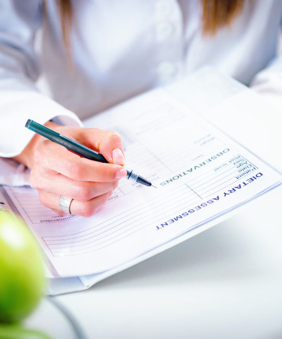 female nutritionist at desk with food and papers