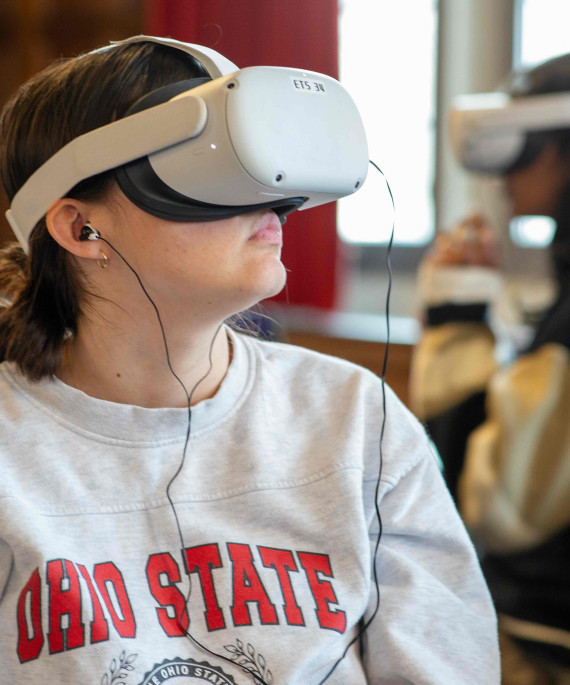 Student in an Ohio State sweatshirt using a virtual reality headset.