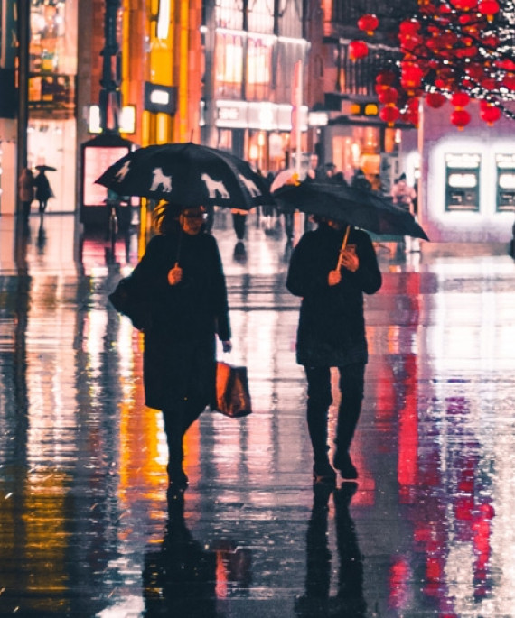 a couple of people walking down a street holding umbrellas