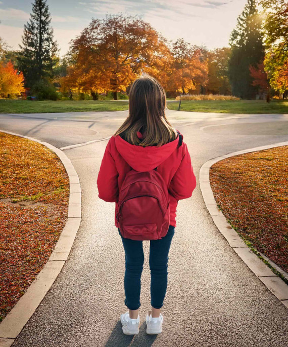 student wearing a backpack looking out onto a fall day on the Oval