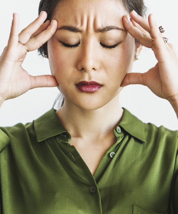 Stressed woman holding forehead