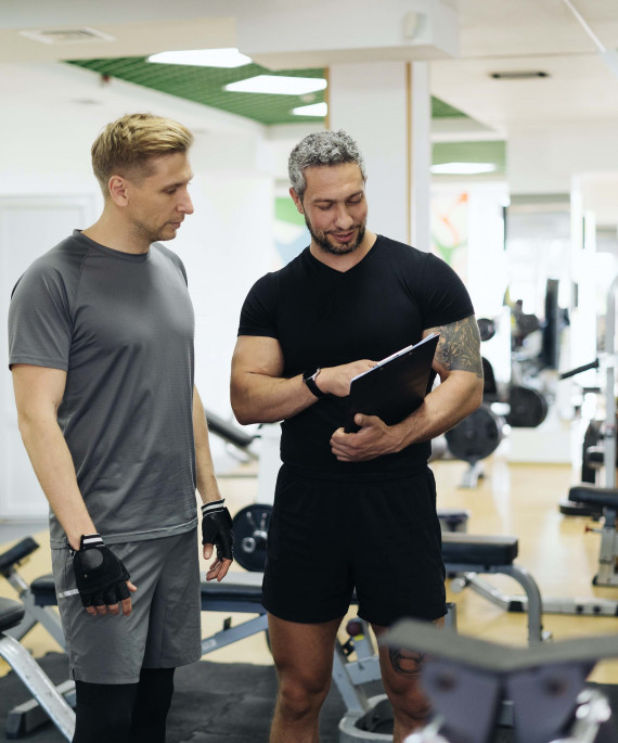 trainer and client in weight room