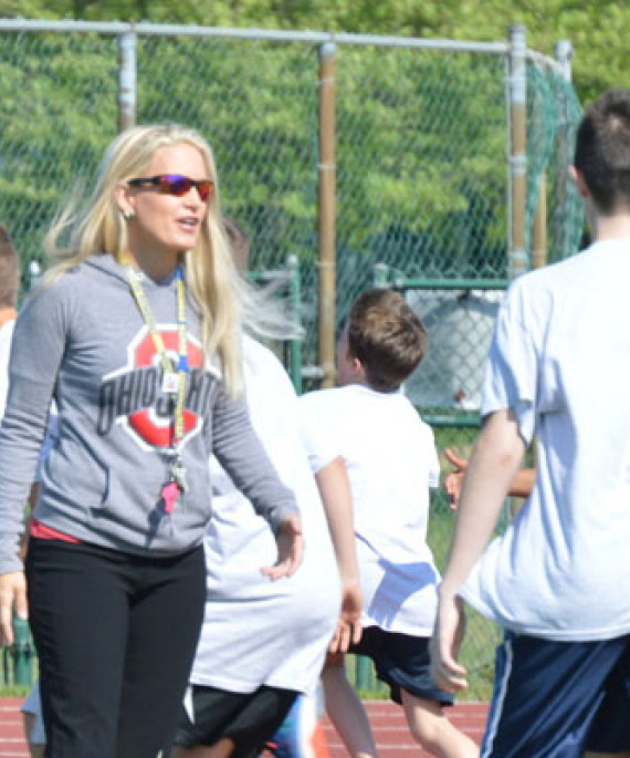 coach talking to a group of young people playing a game