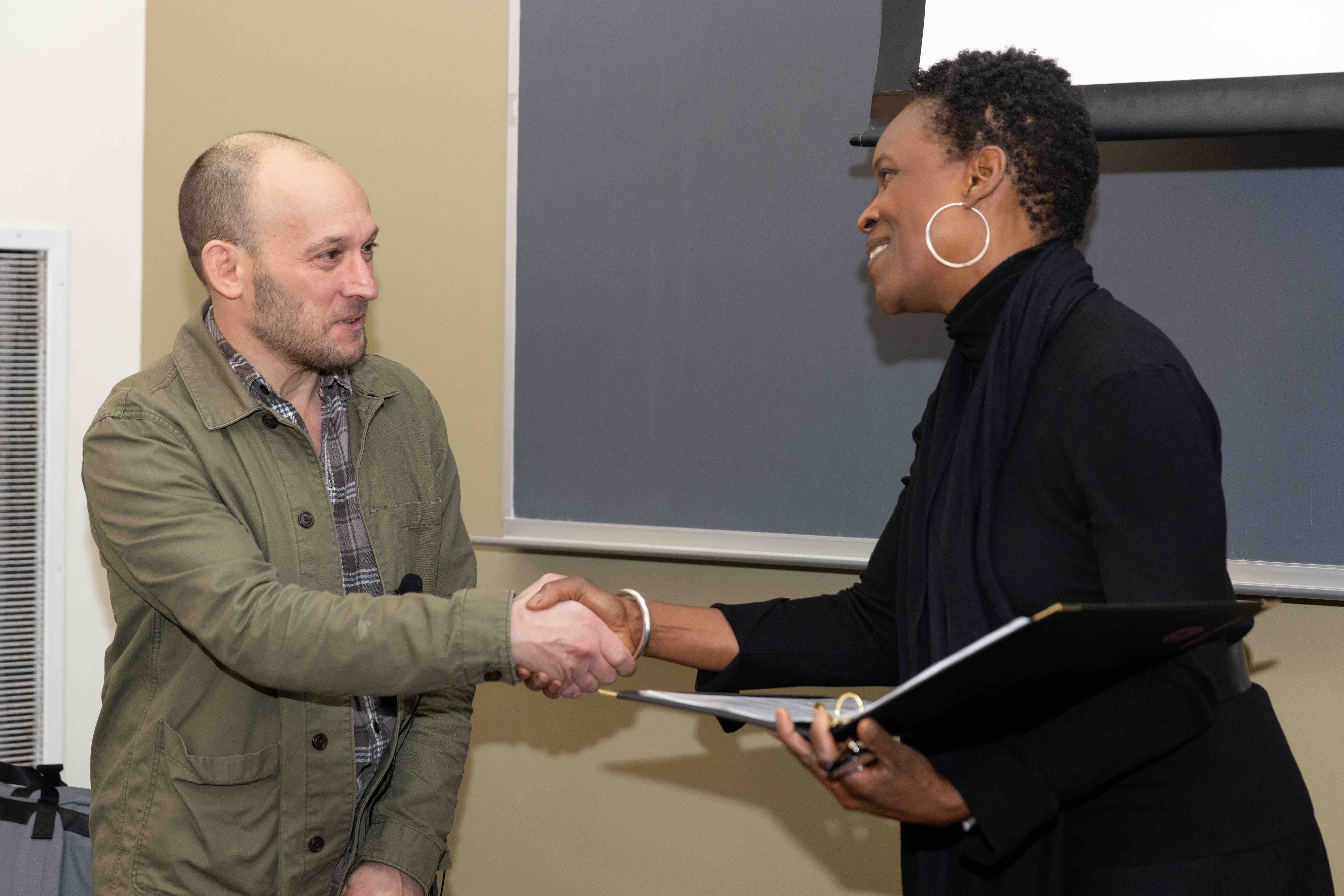 Professor Josh Bomer shaking hands with Provost Melissa Gillam