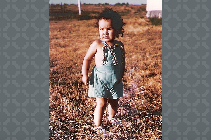 Sandy White Hawk as a child in a field