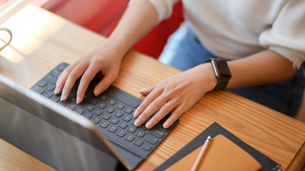 Woman typing on a tablet keyboard